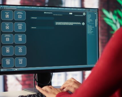 Professional person engaging with an AI chatbot on a computer screen, exploring power of digital assistance through artificial intelligence. Solutions for assistance at desktop. Camera A.